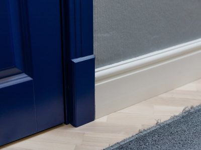 Blue wooden door and adjoining high classic floor plinth. Interior decor elements.