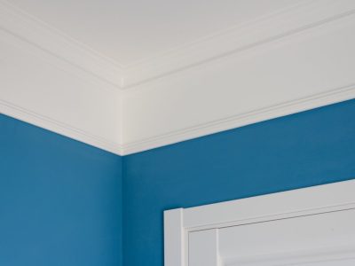 Details in the interior. Ceiling moldings, blue painted walls, white door.