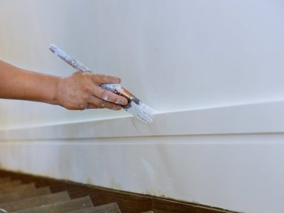 Painting of wooden molding fstairs flooring rame workers hand and brush